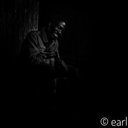 Full length of man looking away while standing against black background