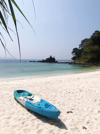 Boat on shore at beach against sky