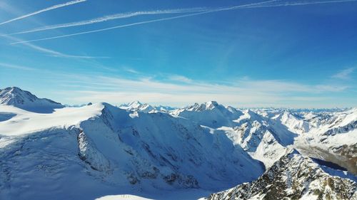 Scenic view of snowcapped mountains against blue sky