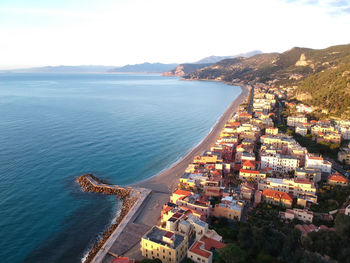 High angle view of city by sea against sky