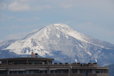 Built structure on snowcapped mountain against sky