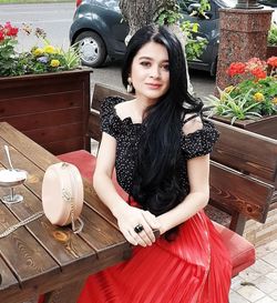 Portrait of a smiling young woman sitting outdoors