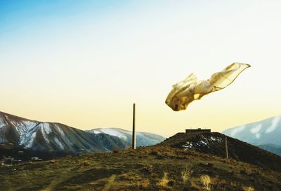 Fabric in mid-air over mountains against clear sky