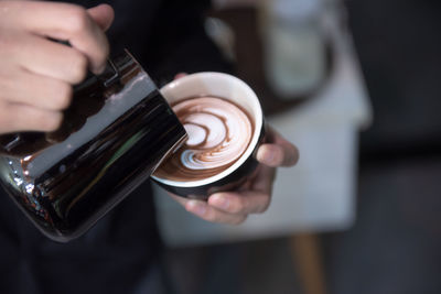 Close-up of hand holding coffee cup