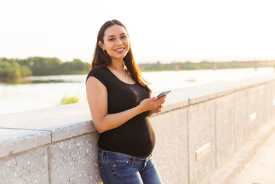 Portrait of smiling young woman standing outdoors