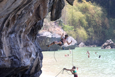 Group of people on rock by mountain