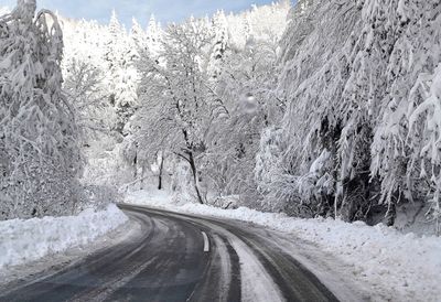 Snow covered road against sky