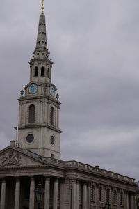 Low angle view of clock tower against cloudy sky