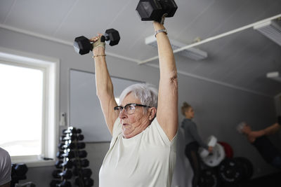 Woman exercising with dumbbells in gym