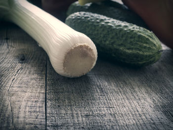 Close-up of leek and cucumbers on table