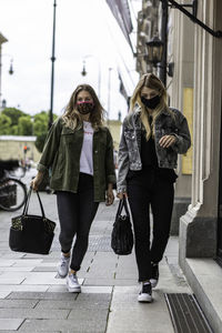 Rear view of women walking on footpath