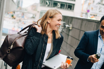 Tilt shot of smiling mature business colleagues on staircase in city