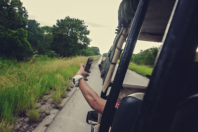 Low section of woman sitting on motorcycle against sky
