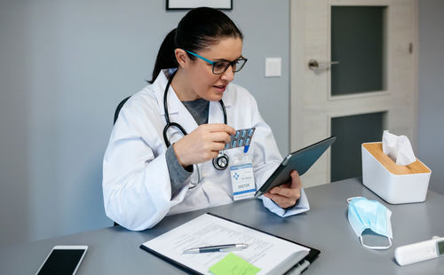 Young woman using mobile phone on table