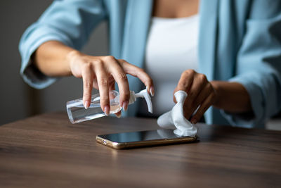 The woman cleans the cell phone with a wet wipe napkin stock photo