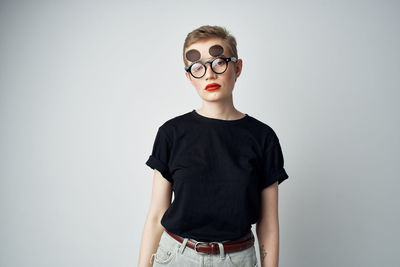 Portrait of teenage girl standing against white background