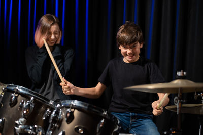 Boy with trainer playing drums