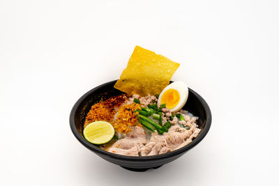Close-up of meal served in bowl against white background