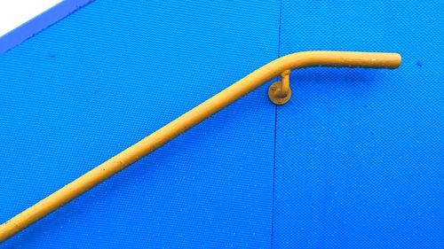 Close-up of railing on blue wall