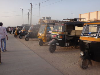 Vehicles on road against sky in city