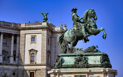 Low angle view of statue against clear blue sky