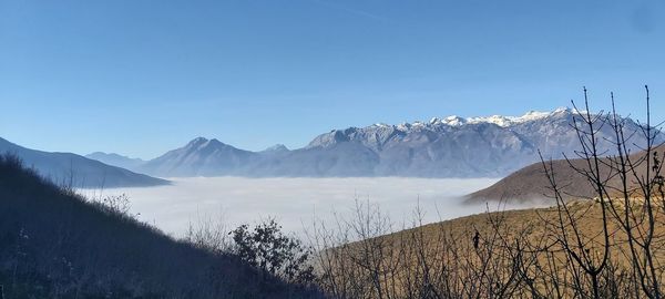 Scenic view of snowcapped mountains against clear blue sky