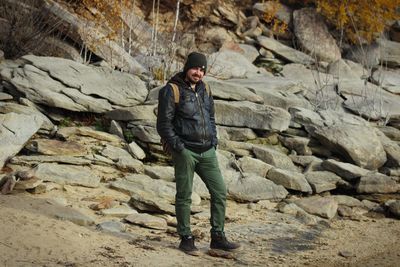 Portrait of man standing against rocks