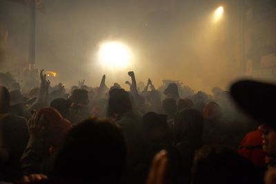 Close-up of hands raising against bright light