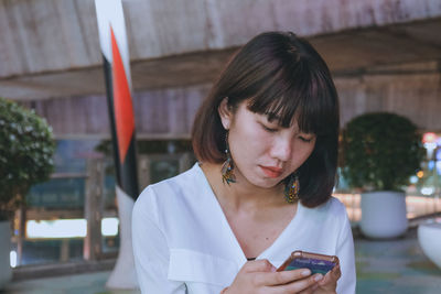 Close-up of woman using mobile phone outdoors