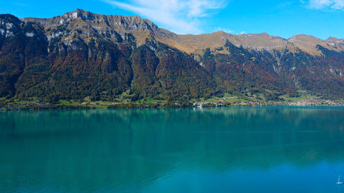 Scenic view of lake by mountains against sky