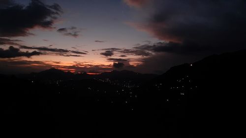 Scenic view of silhouette mountains against dramatic sky