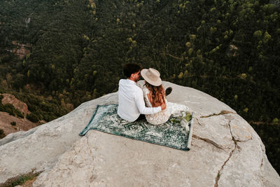 Rear view of couple sitting outdoors