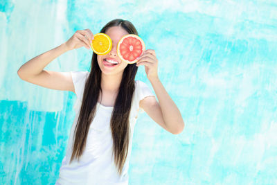 Portrait of young woman holding ice cream in water