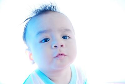 Close-up portrait of cute baby against white background