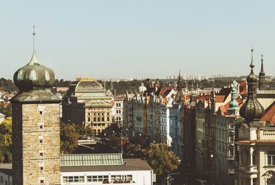 Buildings in city against clear sky