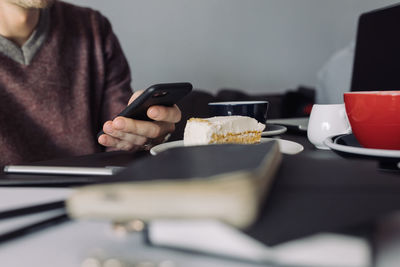 Midsection of man using mobile phone