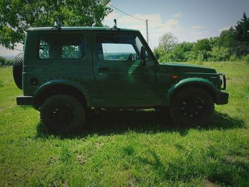 Vintage car on field against trees