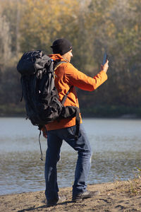 Portrait of traveler man at lake in autumn