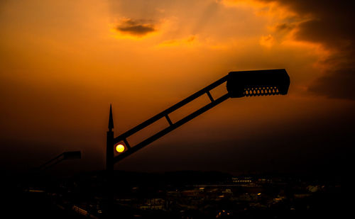 Low angle view of illuminated bridge against sky during sunset