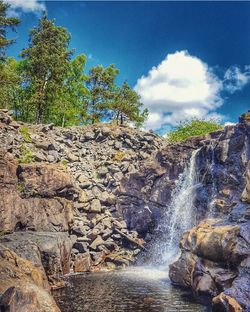 Scenic view of waterfall against sky