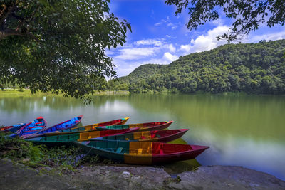 Boat moored in lake against sky