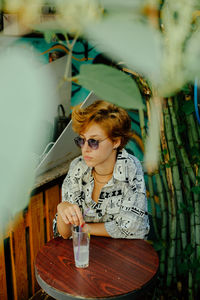 Portrait of young woman sitting on table