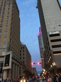 Low angle view of illuminated buildings against sky in city