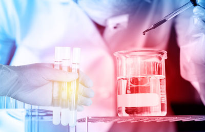 Cropped hand of scientist holding chemical in test tubes at laboratory