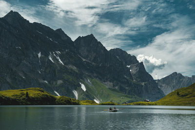 Scenic view of lake by mountains against sky