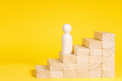 Close-up of chess pieces on yellow background