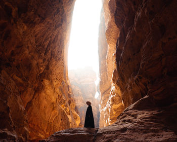 Full length of teenage girl standing amidst rock formation