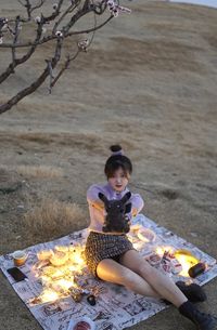 Side view of woman sitting on rock