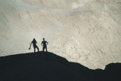 Silhouette men standing on rock