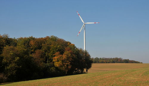 Windmill on field against clear sky